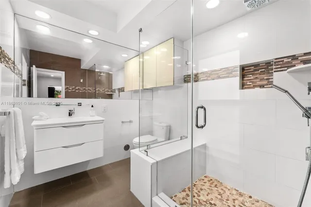 a bathroom with a sink a toilet and shower