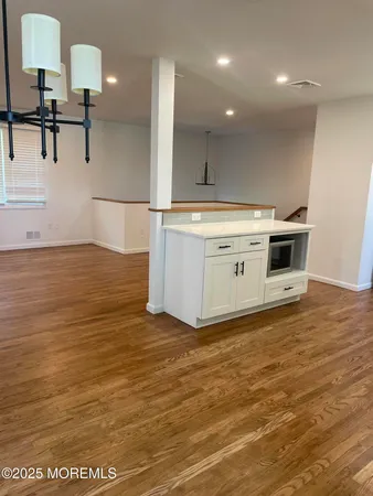 a view of a kitchen with kitchen island a sink stainless steel appliances and cabinets
