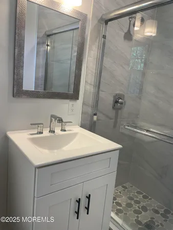 a bathroom with a sink a mirror and a shower