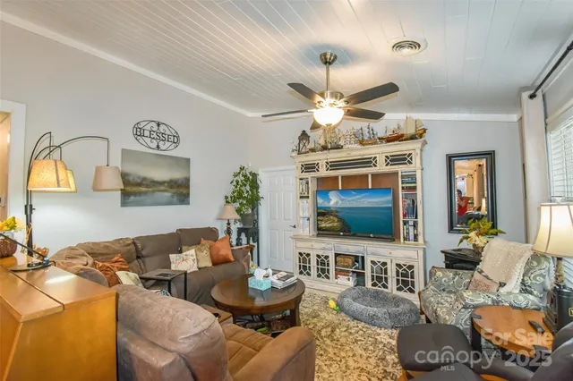 a living room with furniture a chandelier and a flat screen tv