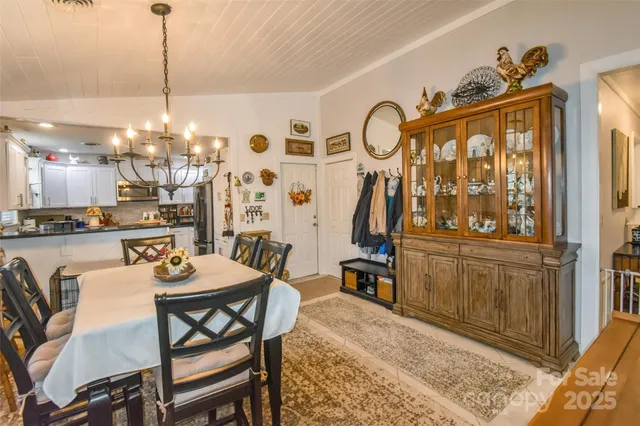 a dining room with furniture a chandelier and window