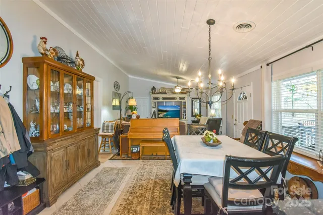 a view of a dining room with furniture a chandelier and wooden floor
