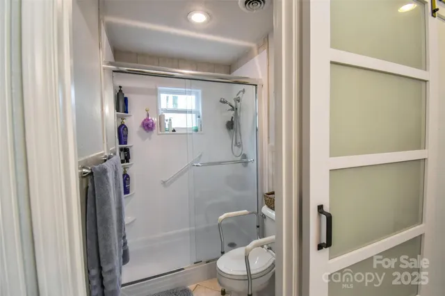 a bathroom with a glass door shower and toilet