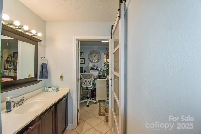 a en suite bathroom with a sink mirror and shower