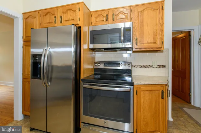 a kitchen with stainless steel appliances granite countertop a refrigerator and a microwave