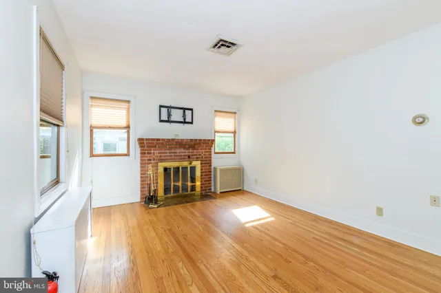 a view of a livingroom with wooden floor and a fireplace