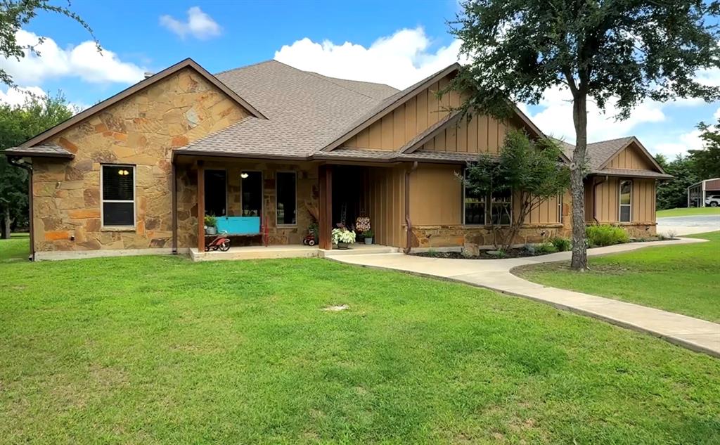 a front view of a house with a yard and tree