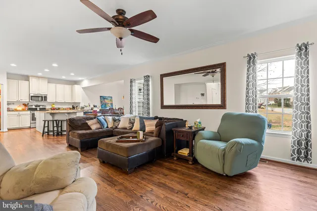 a living room with furniture ceiling fan and a window