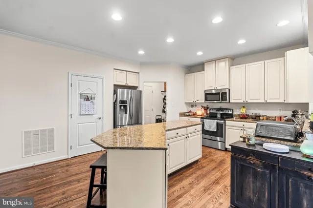 a kitchen with refrigerator cabinets and wooden floor
