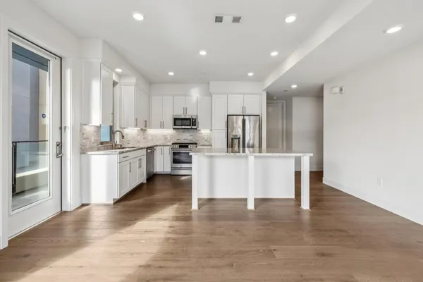 a kitchen with a granite countertop sink and natural light