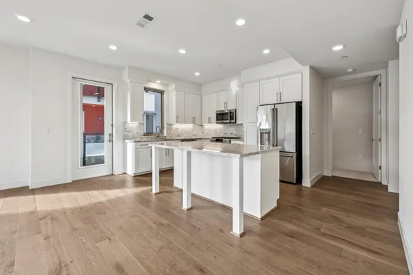 a kitchen with granite countertop a sink a counter top space stainless steel appliances and cabinets