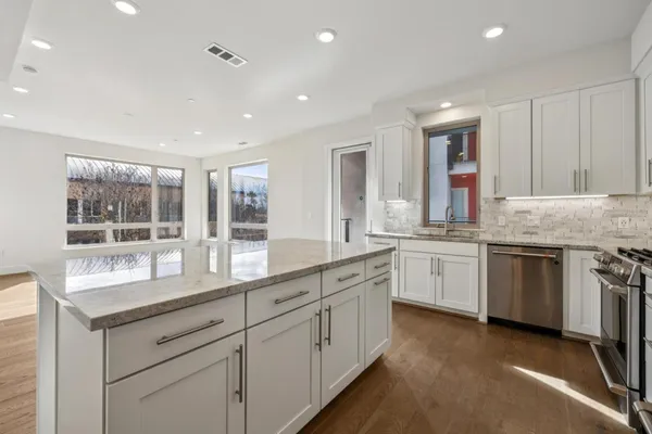 a kitchen with stainless steel appliances granite countertop a stove and a refrigerator