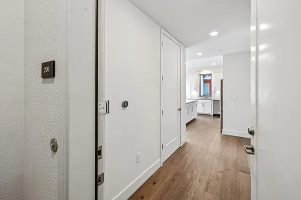 a view of a kitchen with white cabinets and stainless steel appliances