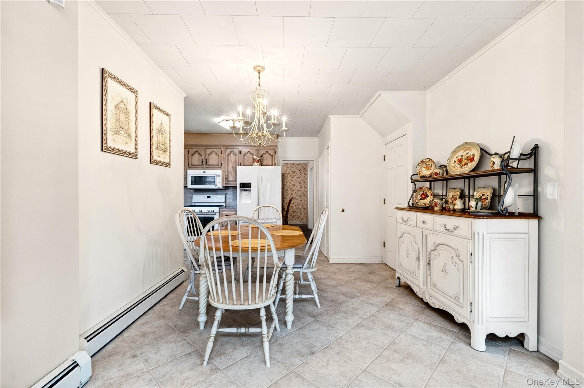 3334 Country Club Road Bronx, NY 10465 - Photo 17 of 49 Dining room featuring a baseboard radiator, ornamental molding, a chandelier, and light tile patterned floors