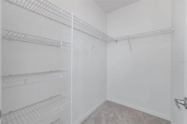 an empty room with a window and a ceiling fan