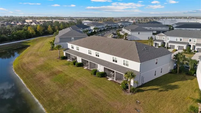 an aerial view of residential houses with yard and mountain view in back