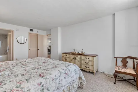 a spacious bedroom with a bed and a chair