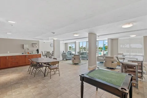 a living room with furniture a large window and wooden floor