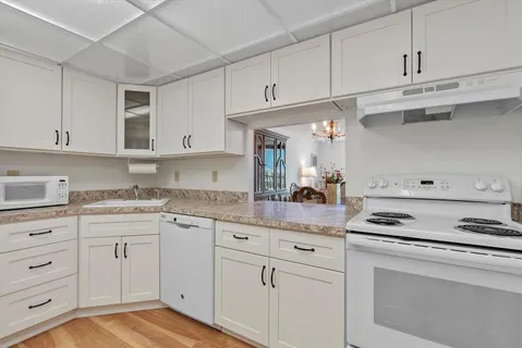 a kitchen with white cabinets and appliances