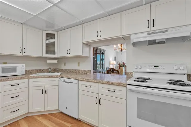 a kitchen with white cabinets and appliances