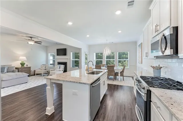 a kitchen with a stove sink cabinets and wooden floor