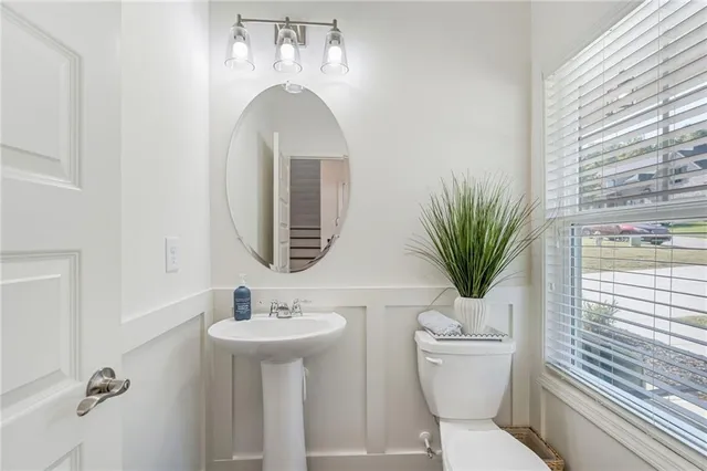 a bathroom with a toilet a sink and a mirror