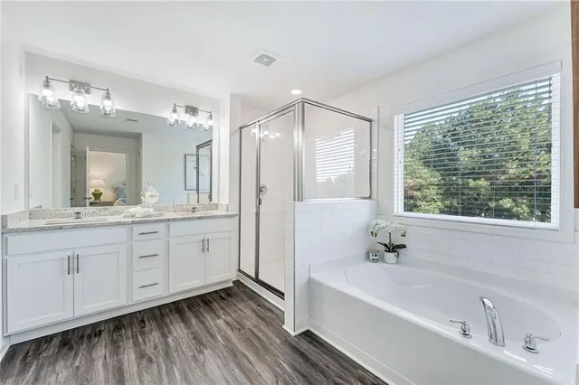 a spacious bathroom with a tub sink and mirror