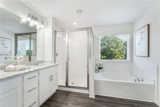 a bathroom with a tub a sink and a large mirror