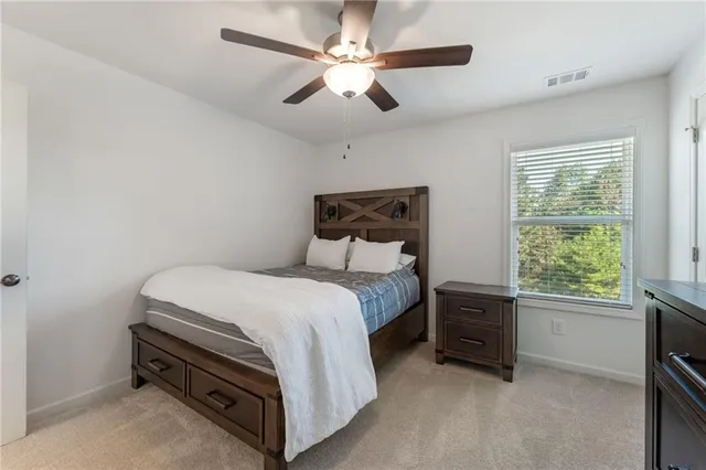 a bed room with a bed and a ceiling fan