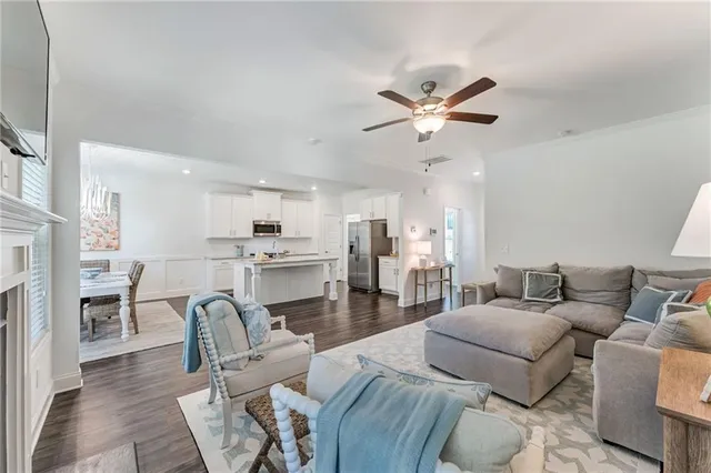 a living room with furniture a fireplace and a ceiling fan