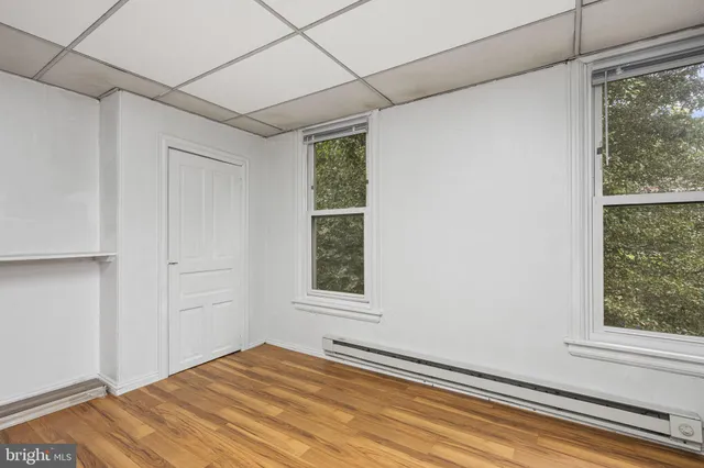 a view of a room that has a window and a wooden floor