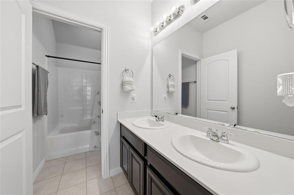 4542 Kipling Avenue Aubrey, TX 76227 - Photo 25 of 34 a bathroom with a sink a shower a mirror and a bathtub