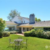 a view of a house with a yard potted plants and a table