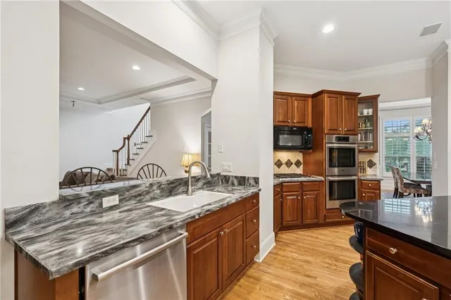 a kitchen with stainless steel appliances granite countertop a sink and stove