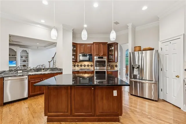 a kitchen with stainless steel appliances granite countertop a refrigerator and a stove