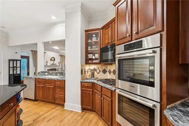 a kitchen with stainless steel appliances granite countertop a stove a sink and a refrigerator