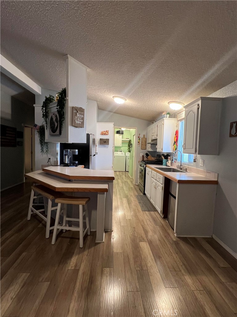 2020 Ashby Road, Unit 22 Merced, CA 95348 - Photo 17 of 25 a kitchen with kitchen island stainless steel appliances a stove and wooden floor