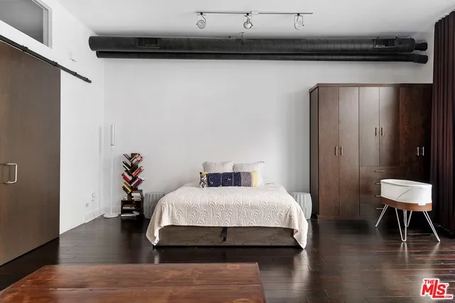 a bedroom with a bed and a potted plant