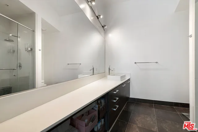 a bathroom with a sink a mirror and a shower