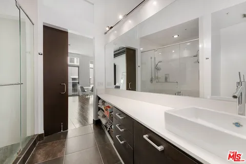 a spacious bathroom with a shower sink and mirror