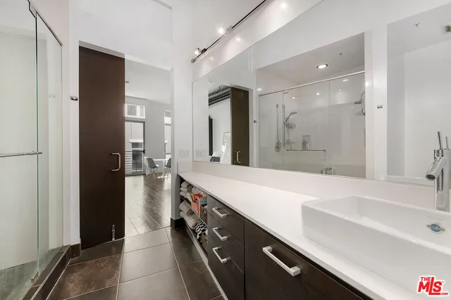 a spacious bathroom with a shower sink and mirror