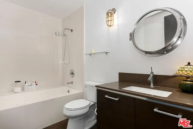 a bathroom with a sink a toilet and a mirror