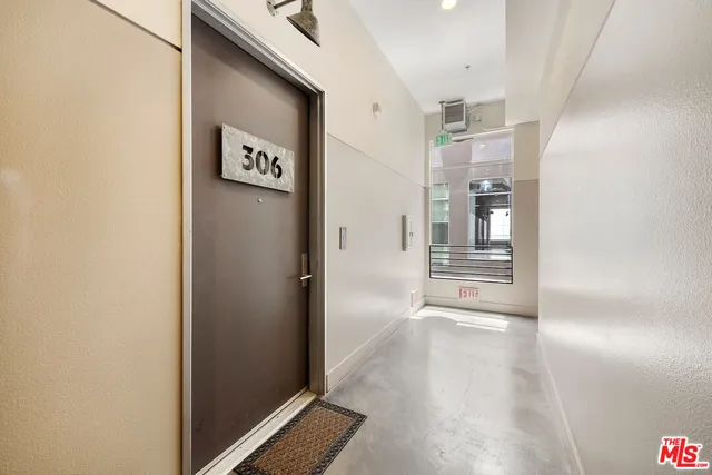 a view of a hallway with wooden floor and a bathroom