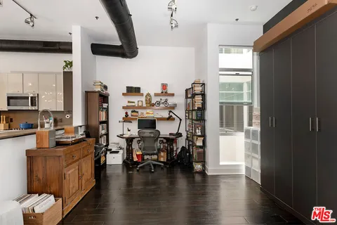 a kitchen with stainless steel appliances kitchen island granite countertop a table chairs in it and wooden floors