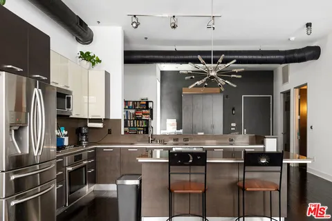 a kitchen with stainless steel appliances kitchen island granite countertop a sink and cabinets