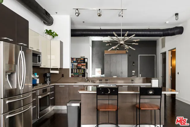 a kitchen with stainless steel appliances kitchen island granite countertop a sink and cabinets