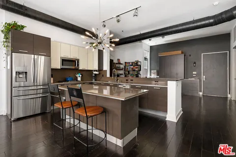 a kitchen with kitchen island granite countertop a sink appliances and cabinets