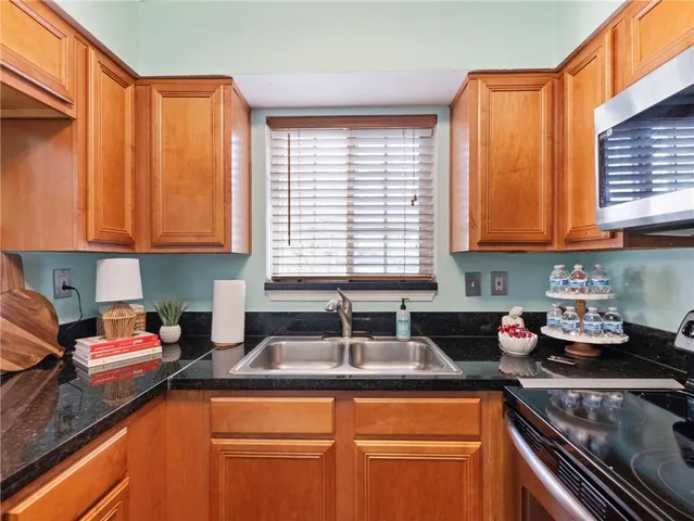 a kitchen with stainless steel appliances granite countertop sink stove and cabinets