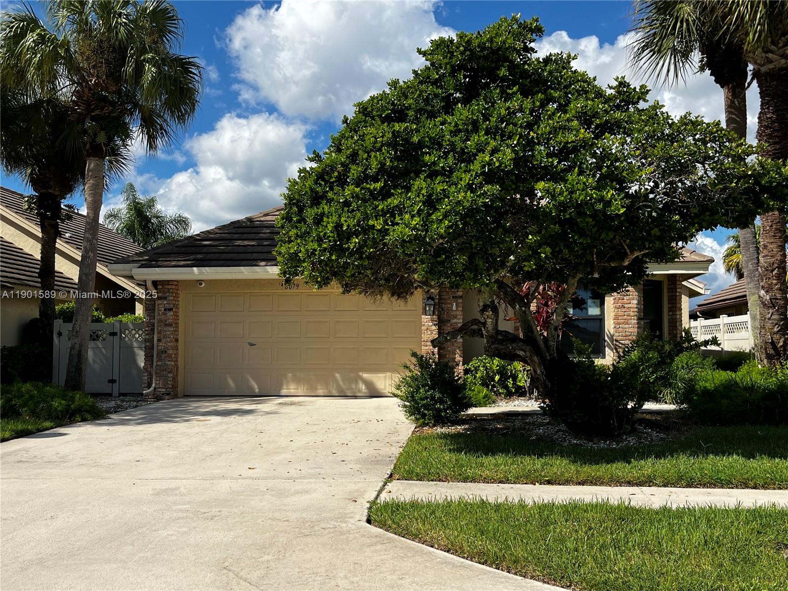 a view of a house with a yard and potted plants