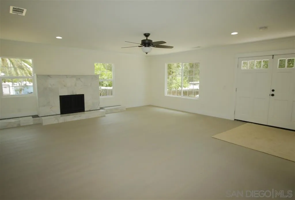 15726 Mussey Grade Road Ramona, CA 92065 - Photo 3 of 17 an empty room with windows and fireplace
